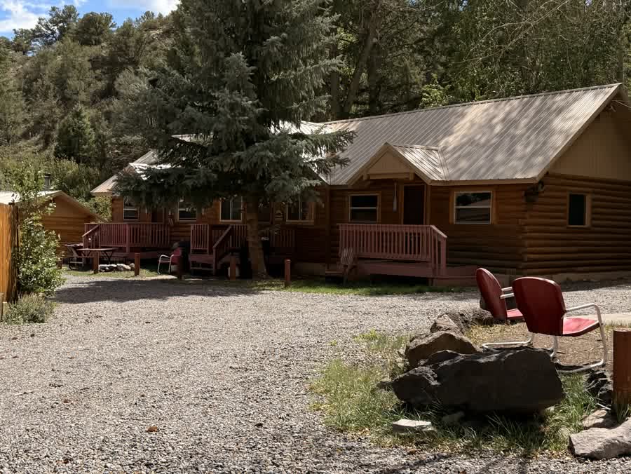 A row of log cabins with metal roofs