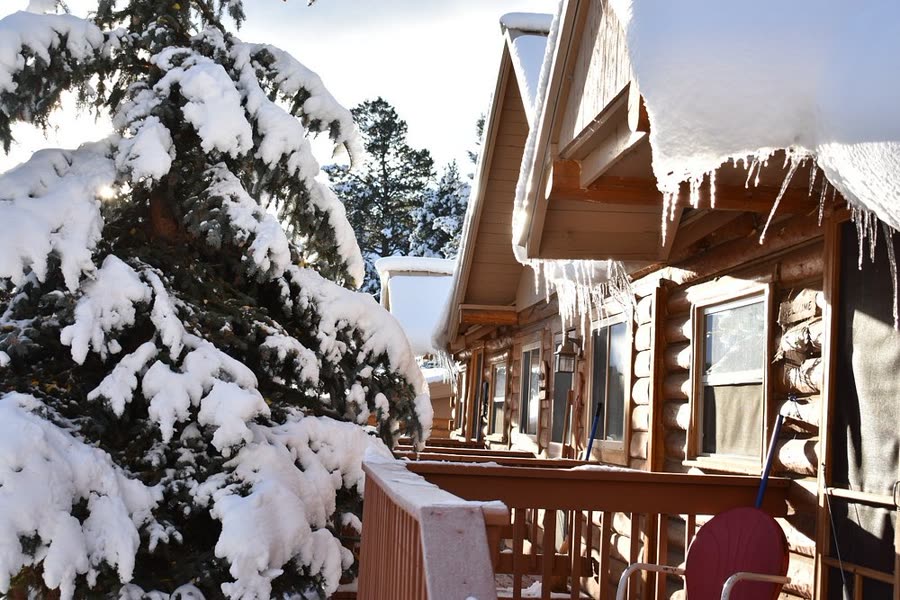 Snow piled on cabin roofs and porch rails