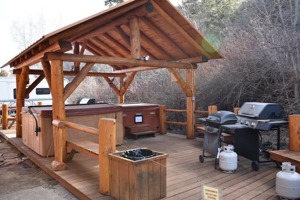 Covered timber gazebo with a hot tub and gas grills