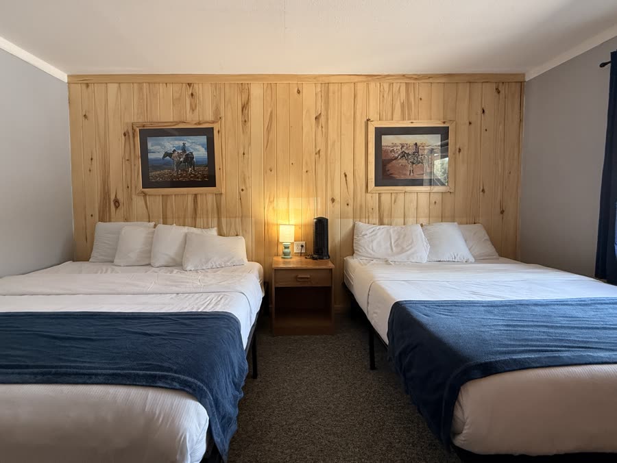 Lodge room with two queen beds and pine-panelled walls