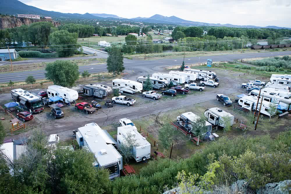 Aerial view of RVs parked in rows with the valley and mountains beyond