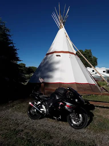 The tipi lit against a deep blue evening sky